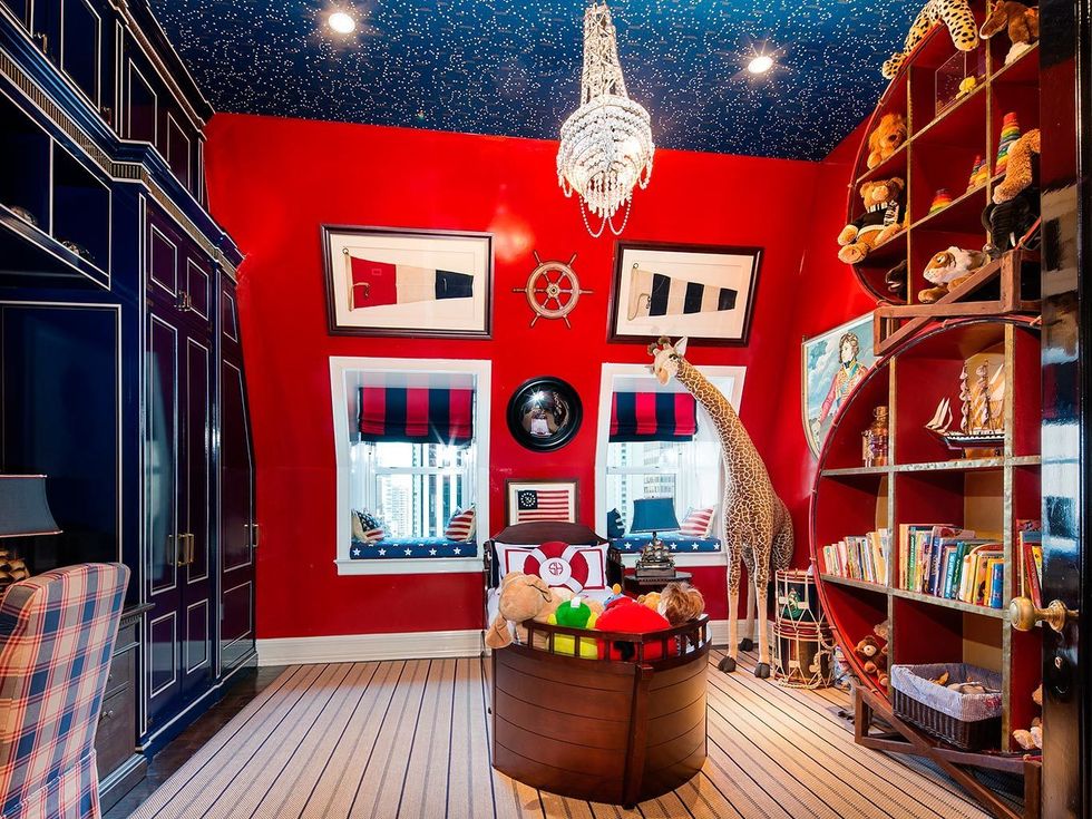 <p>La casa también cuenta con un dormitorio infantil, decorado en los dos colores más emblemáticos del diseñador: el rojo y el azul marino. En el centro, una divertida cama con forma de barca. </p>