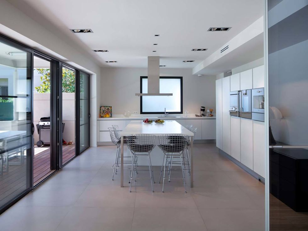 <p>Una cocina muy moderna y minimalista, de blanco impoluto, con abundante luz natural y fácil acceso a la terraza y zona de barbacoa.</p>