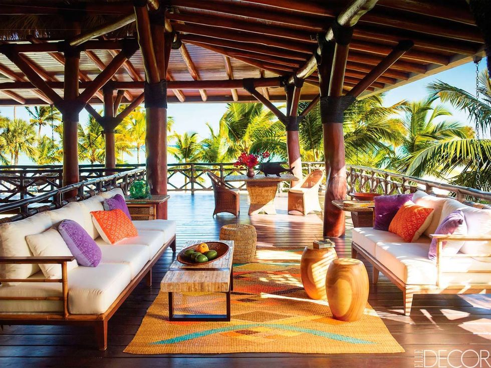 <p>En esta casa de vacaciones de República Dominicana, decorada por Juan Montoya, el porche está equipado con unos sofás y cojines de México. Los taburetes de madera y las mesitas de mimbre se adquirieron por la zona, y la alfombra es colombiana.</p>