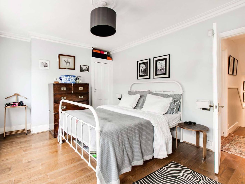 <p>Dormitorio principal decorado en tonos neutros y muebles de madera oscura que contrastan con las paredes blancas. Como en el resto de la casa lo clásico y lo moderno se mezclan para dar lugar a un ambiente híbrido.</p>