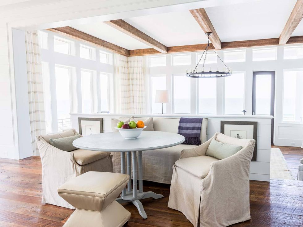 <p>Un pequeño apartado al lado del salón sólo separado por un bajo muro blanco. Una mesa simple y circular en color gris rodeada de sillas y taburetes en un sutil color tierra .</p>