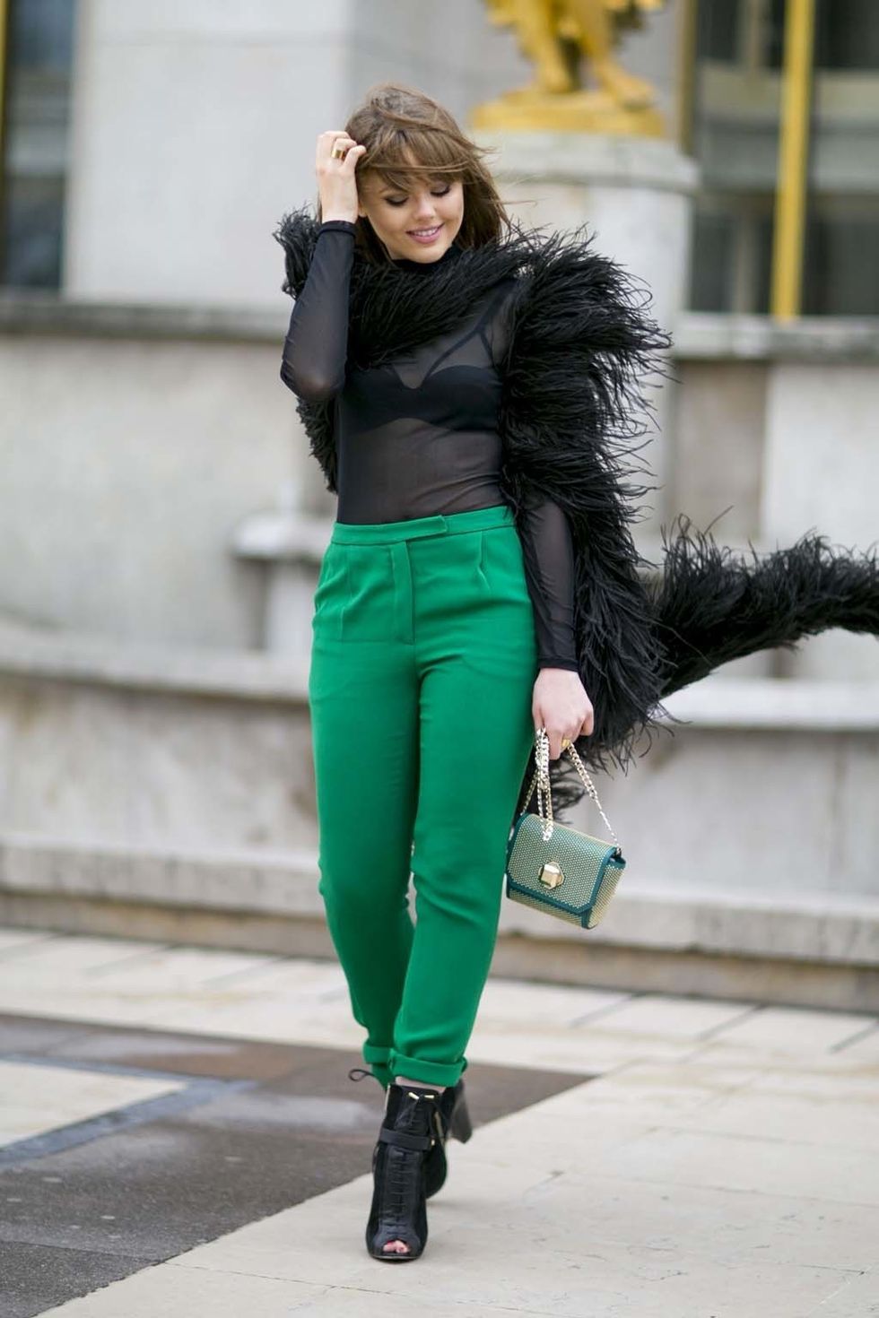 <p>La bloguera se atreve a remangar unos pantalones rectos en verde y a combinarlos con transparencias y plumas negras.&nbsp;</p>