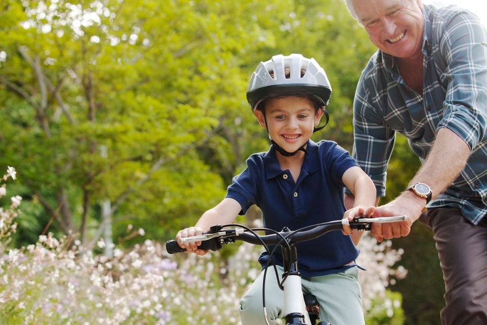 abuelo enseñando a montar en bici a su nieto