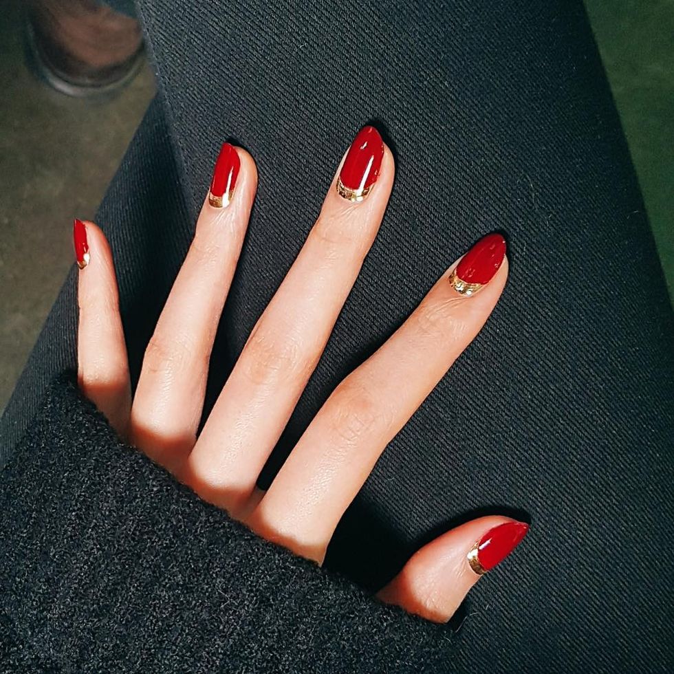<p>Make a red nail instantly glamorous with a metallic accent. Start with a clear base coat, then paint your half moons in gold. Let dry, then fill in the rest of the nail in your favorite red polish. Finish with a top coat. </p>

<p><em data-verified="redactor" data-redactor-tag="em">Design by <a href="https://www.instagram.com/p/BMwmq99gs-B/" data-tracking-id="recirc-text-link" target="_blank">@nail_unistella</a></em></p>