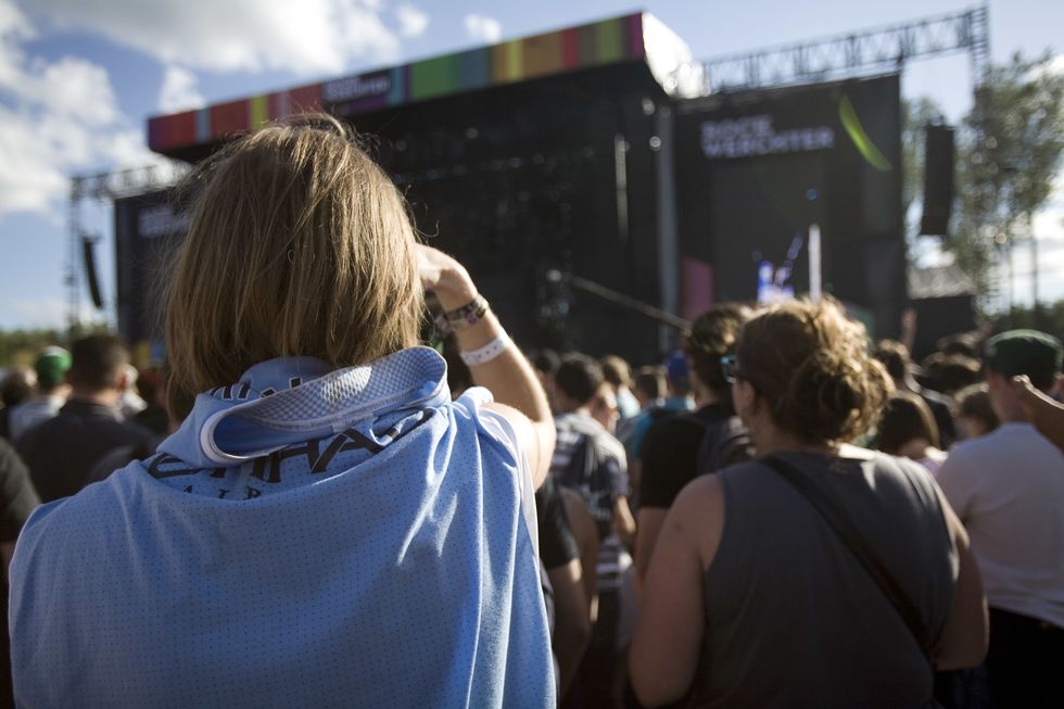 A fan looks on at the stage, wearing a Manchester City top around her shoulders as Noel Gallagher performs on stage at the Rock Werchter Festival, Belgium, 1st July 2012. (Photo by Kevin Cummins/Getty Images)