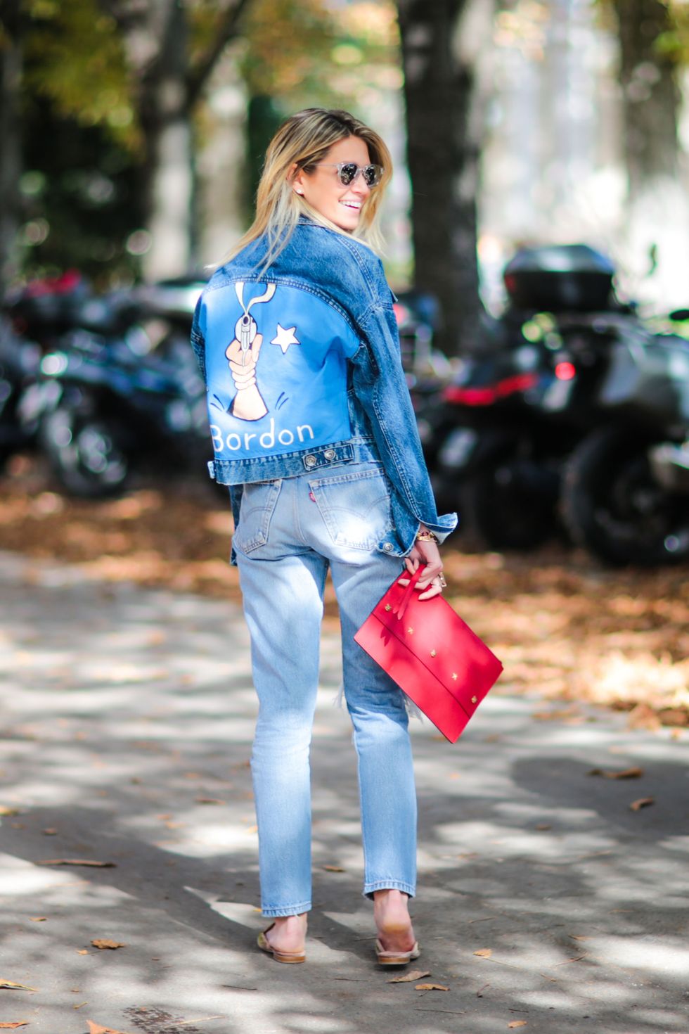 PARIS, FRANCE - OCTOBER 03:  Helena Bordon wears blue denim jeans, a blue denim jacket with her name written on the back, a red clutch, and sunglasses, outside of the Giambattista Valli show during Paris Fashion Week Spring Summer 2017, at Grand Palais, on October 3, 2016 in Paris, France.  (Photo by Edward Berthelot/Getty Images)