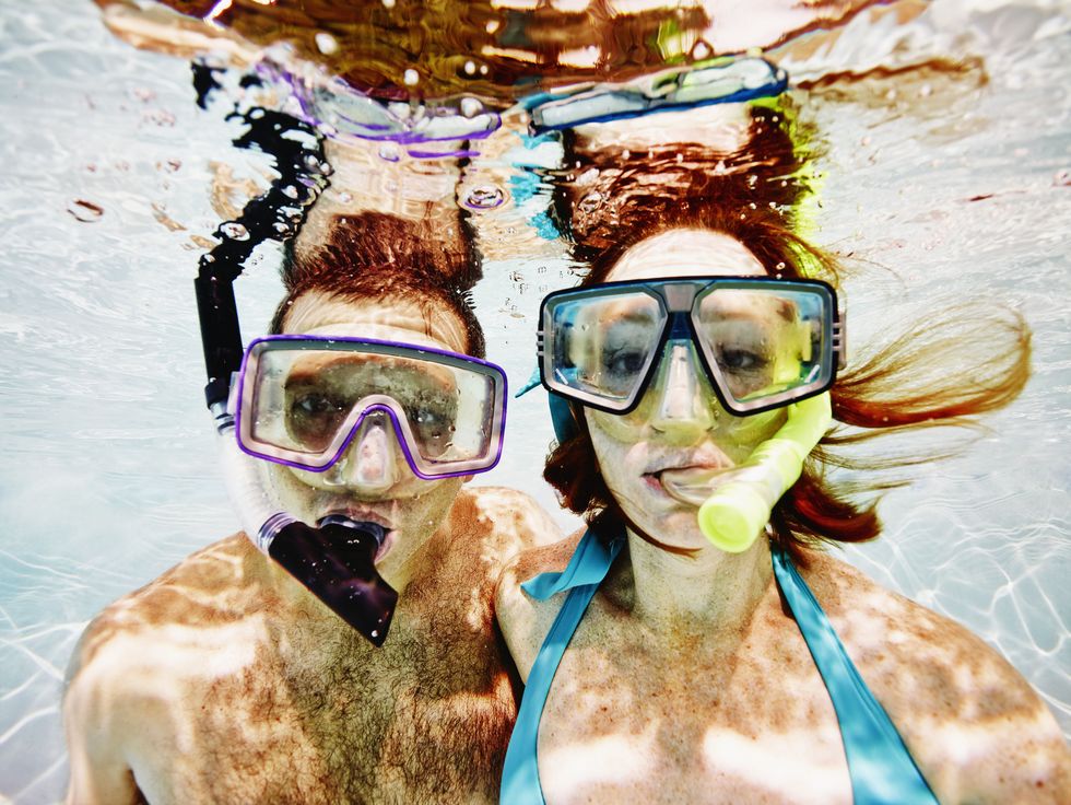 man and woman wearing snorkel masks