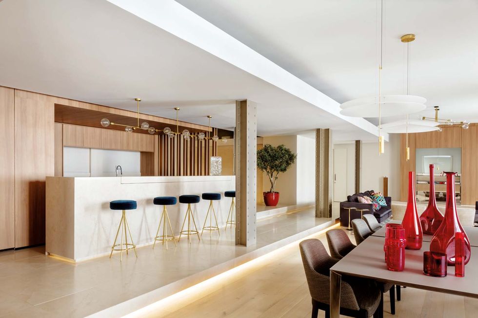 una oficina convertida en casa en la gran via de madrid cocina abierta al salon con barra de marmol