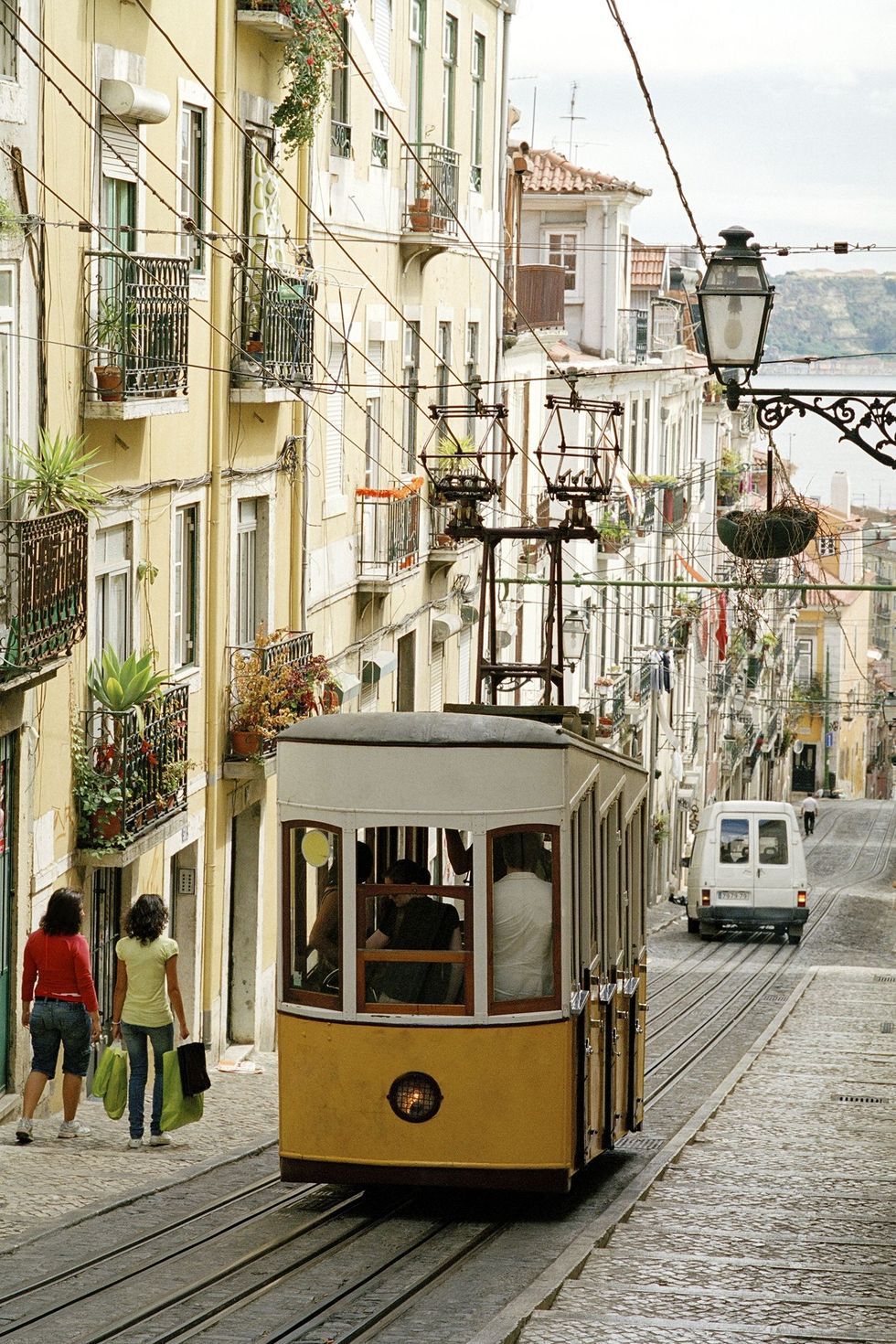 Tram, Transport, Cable car, Mode of transport, Vehicle, Cable car, Yellow, Rolling stock, Town, Urban area, 