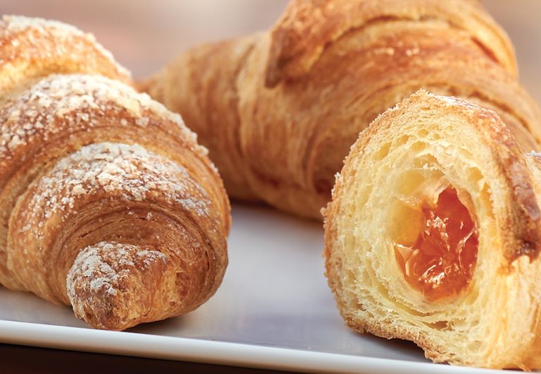 Una perfetta prima colazione con cornetti e cappuccino in un bar. Il blu e  il giallo tazze di ceramica di cappuccino e croissant sul tavolo di legno  con Natale lig Foto stock - Alamy