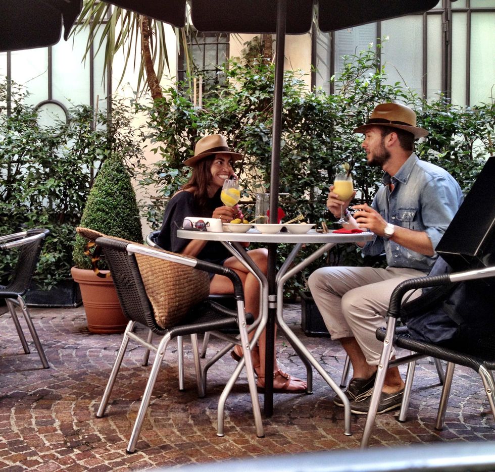 Human body, Furniture, Table, Outdoor furniture, Chair, Sitting, Outdoor table, Hat, Drink, Conversation, 