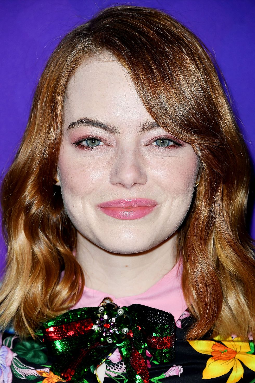<p>Emma Stones swooping bangs and soft waves compliment the width of her round face. </p>