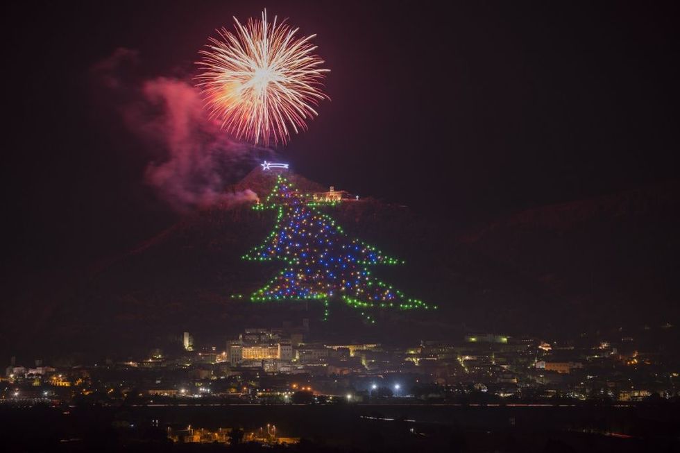 Italy, Umbria, Province of Perugia, Gubbio, Christmas tree on mount Ingino, fireworks