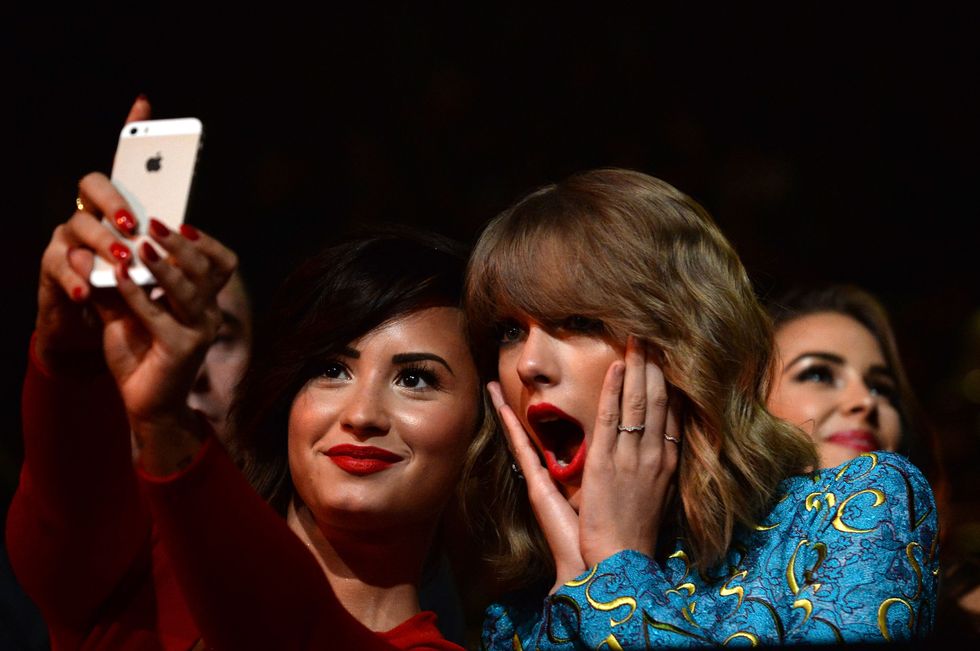 INGLEWOOD, CA - AUGUST 24:  Recording artists Demi Lovato (L) and Taylor Swift take a selfie at the 2014 MTV Video Music Awards at The Forum on August 24, 2014 in Inglewood, California.  (Photo by Jeff Kravitz/MTV1415/FilmMagic)