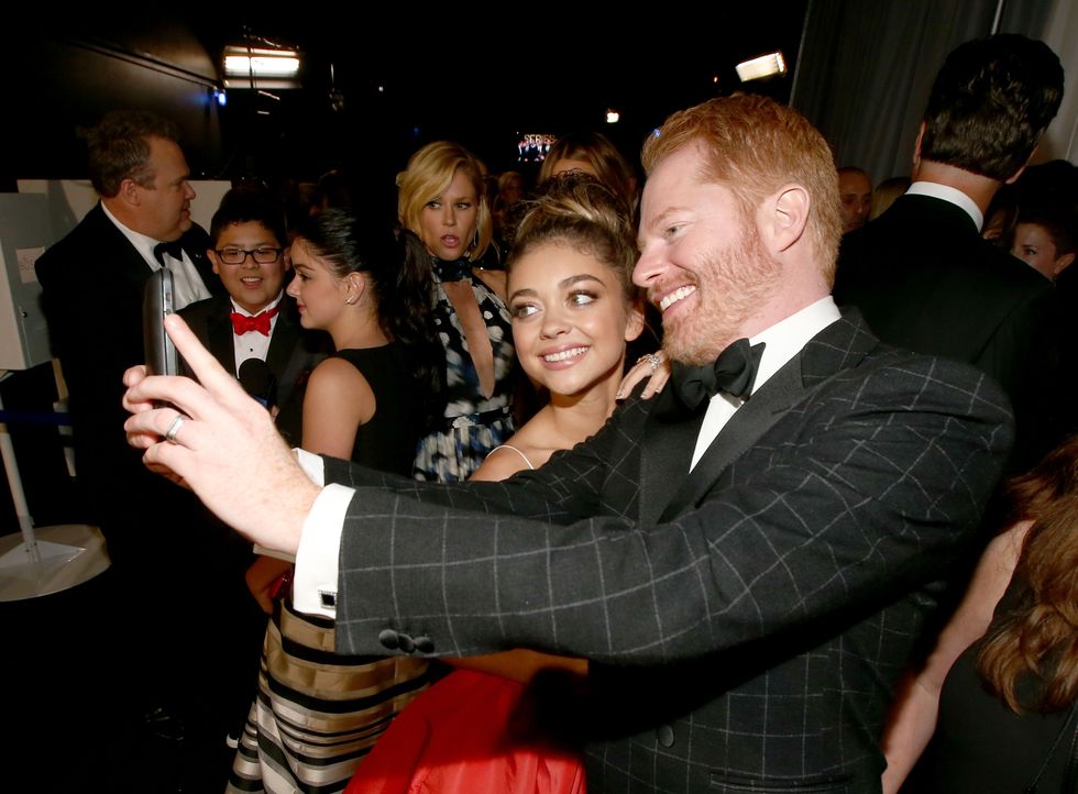 LOS ANGELES, CA - AUGUST 25:  66th ANNUAL PRIMETIME EMMY AWARDS -- Pictured: (l-r) Actors Sarah Hyland and Jesse Tyler Ferguson take a selfie backstage during the 66th Annual Primetime Emmy Awards held at the Nokia Theater on August 25, 2014.  (Photo by Christopher Polk/NBC/NBC via Getty Images)
