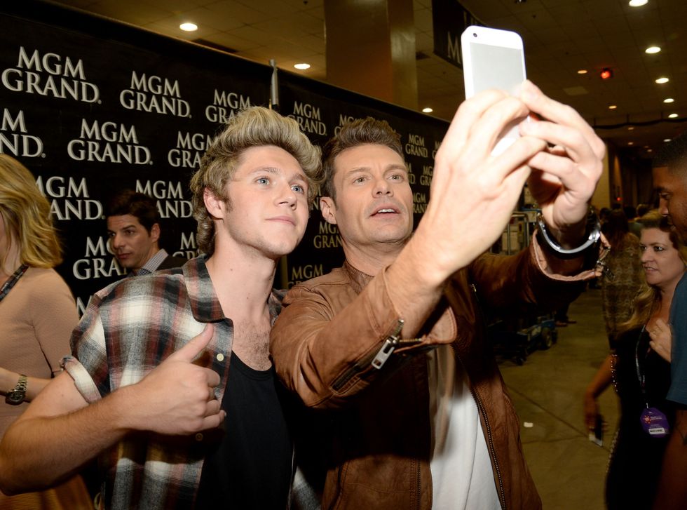 LAS VEGAS, NV - SEPTEMBER 20:  Recording artist Niall Horan (L) of music group One Direction and host Ryan Seacrest take a selfie photo at the 2014 iHeartRadio Music Festival at the MGM Grand Garden Arena on September 20, 2014 in Las Vegas, Nevada.  (Photo by Kevin Mazur/WireImage)