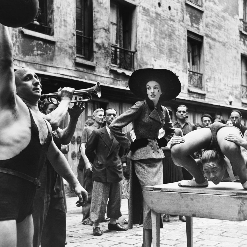 <p>Elise Daniels indossa&nbsp;Balenciaga insieme ad artisti di strada francesi nel Marais parigino, 1948. Foto di Richard Avedon.&nbsp;</p>