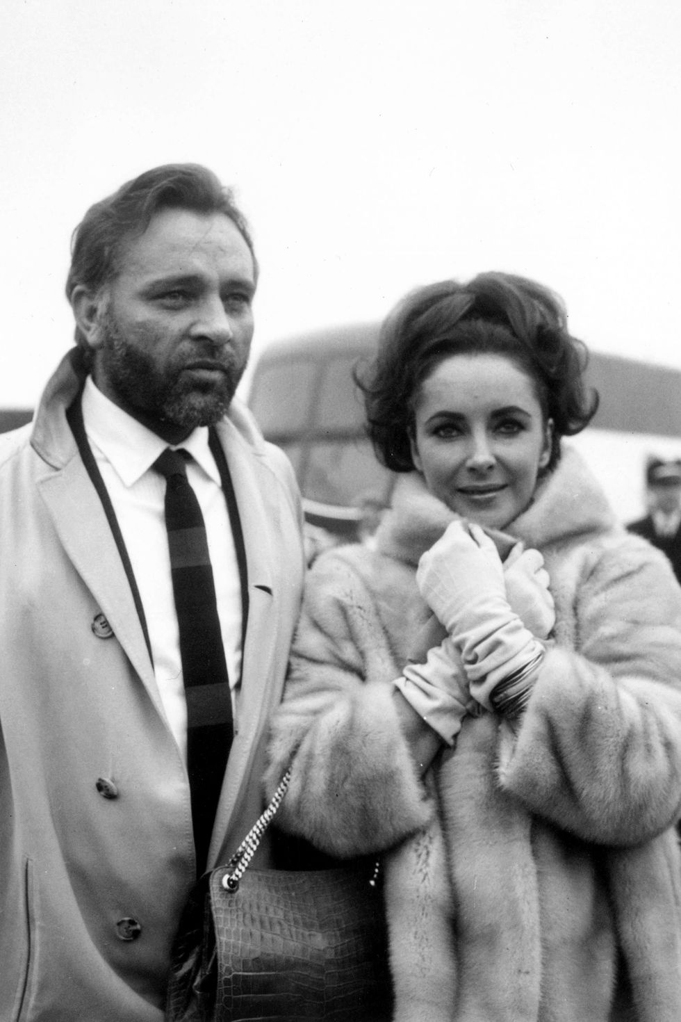1st February 1966:  Welsh stage and film actor Richard Burton (1925 - 1984) with his wife, actress Elizabeth Taylor at London Airport.  (Photo by George Stroud/Express/Getty Images)