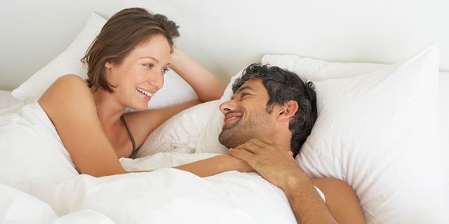 Couple in bed smiling happy