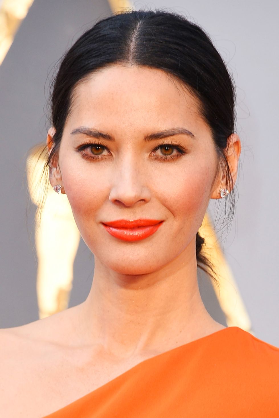 <p>Try and clean updo, but don't slick your hair down. Munn's casual updo leaves the sideburns out, which creates a shadow over the sides of her face. This illusion slims down her face into an oval shape. </p>