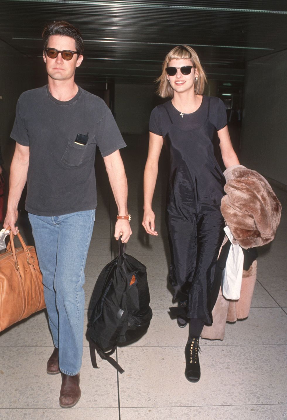 <p> Evangelista pairs the black staple over a simple tee for an effortless airport look, at LAX in 1994. </p>