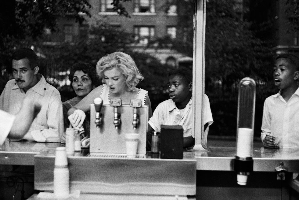 Marilyn Monroe fotografata da Sam Shaw al bancone di un bar di New York mentre mette ketchup sull'hot dog, in mostra alla Galerie de l'Instant di Parigi