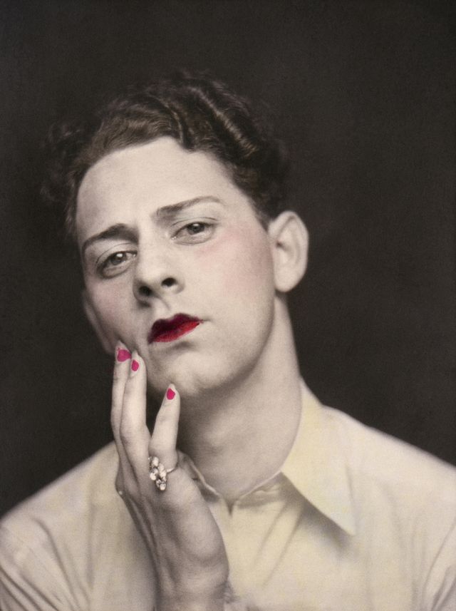 Man in makeup wearing ring. Photograph from a photo booth, with highlights of color. United States, circa 1920. © Sebastian Lifshitz Collection, Courtesy of Sebastian Lifshitz and The Photographers' Gallery