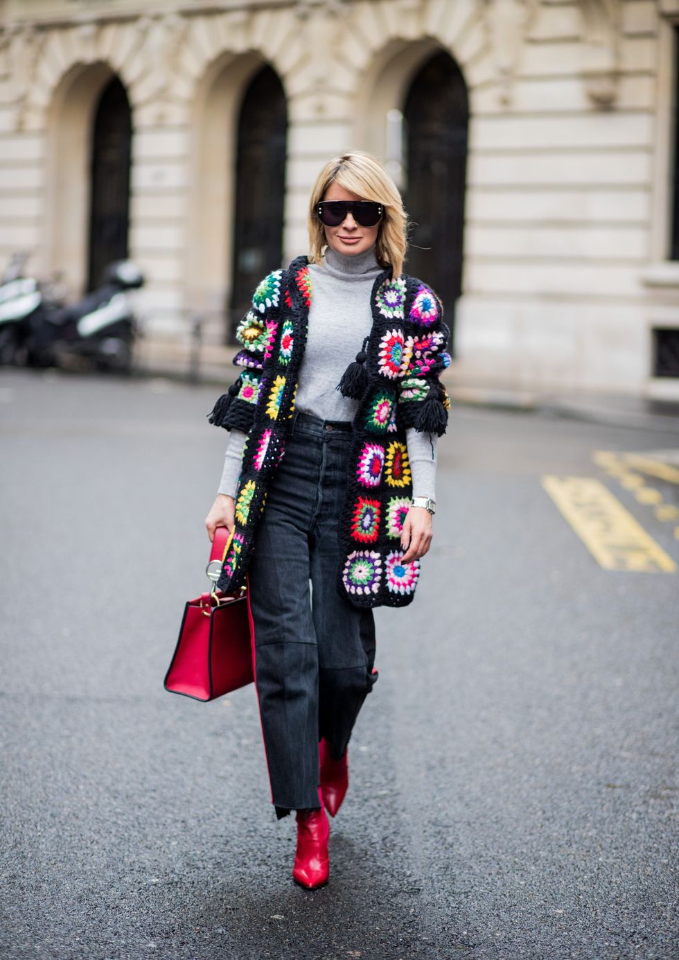 PARIS, FRANCE - MARCH 02: Gitta Banko wearing a multi-colored patchwork cardigan by Amma Mode, light-grey cashmere turtleneck sweater by Bruno Manetti, black jeans with red stripes by Vetements, red sock boots by Fendi, red leather Runaway bag by Fendi, and sunglasses by Dior on March 2, 2018 in Paris, France. (Photo by Christian Vierig/Getty Images)