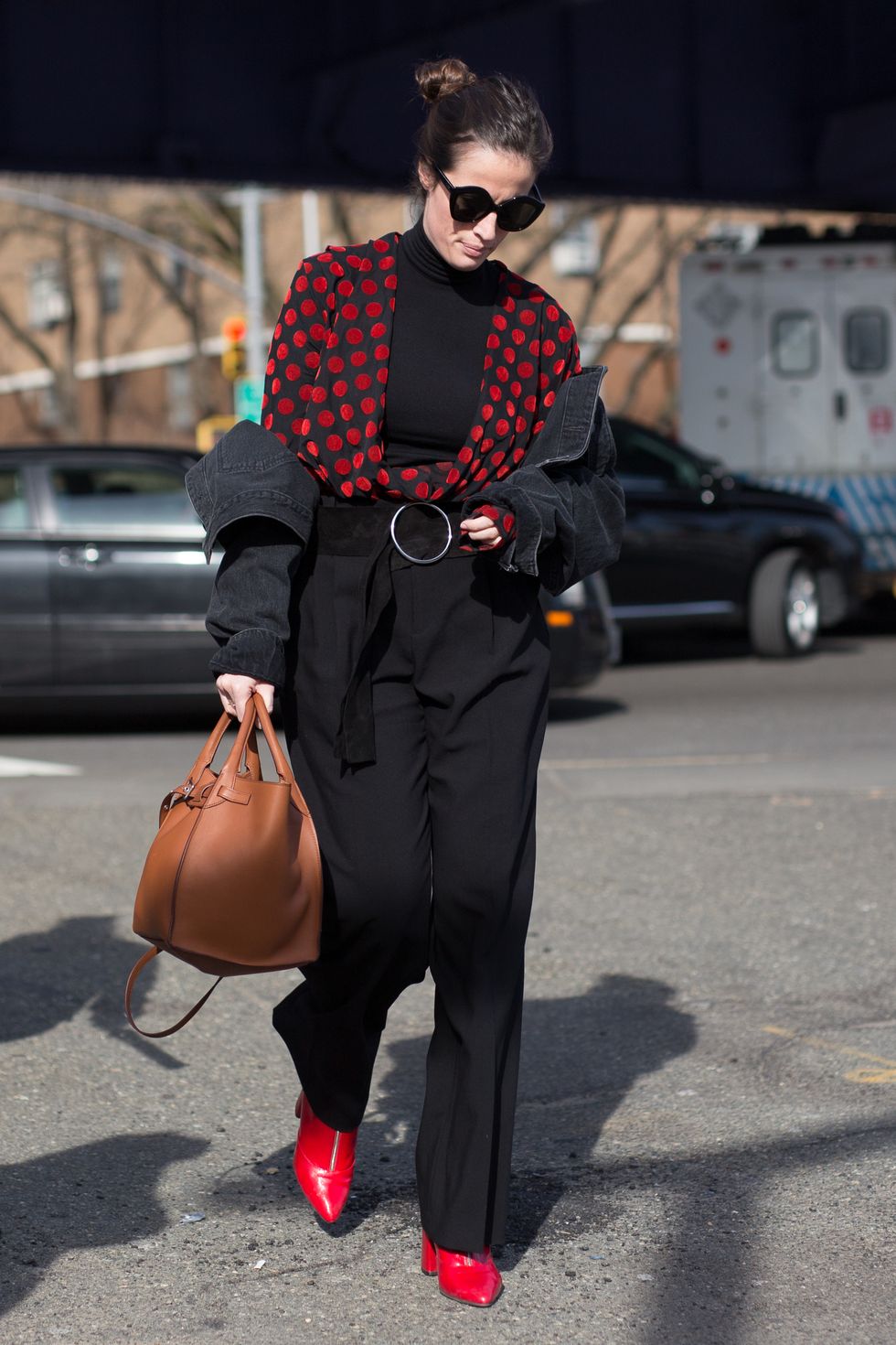 NEW YORK, NY - FEBRUARY 13:  A guest is seen on the street attending Coach 1941 during New York Fashion Week wearing black pants and sweater with red polka-dot cardigan on February 13, 2018 in New York City.  (Photo by Matthew Sperzel/Getty Images)