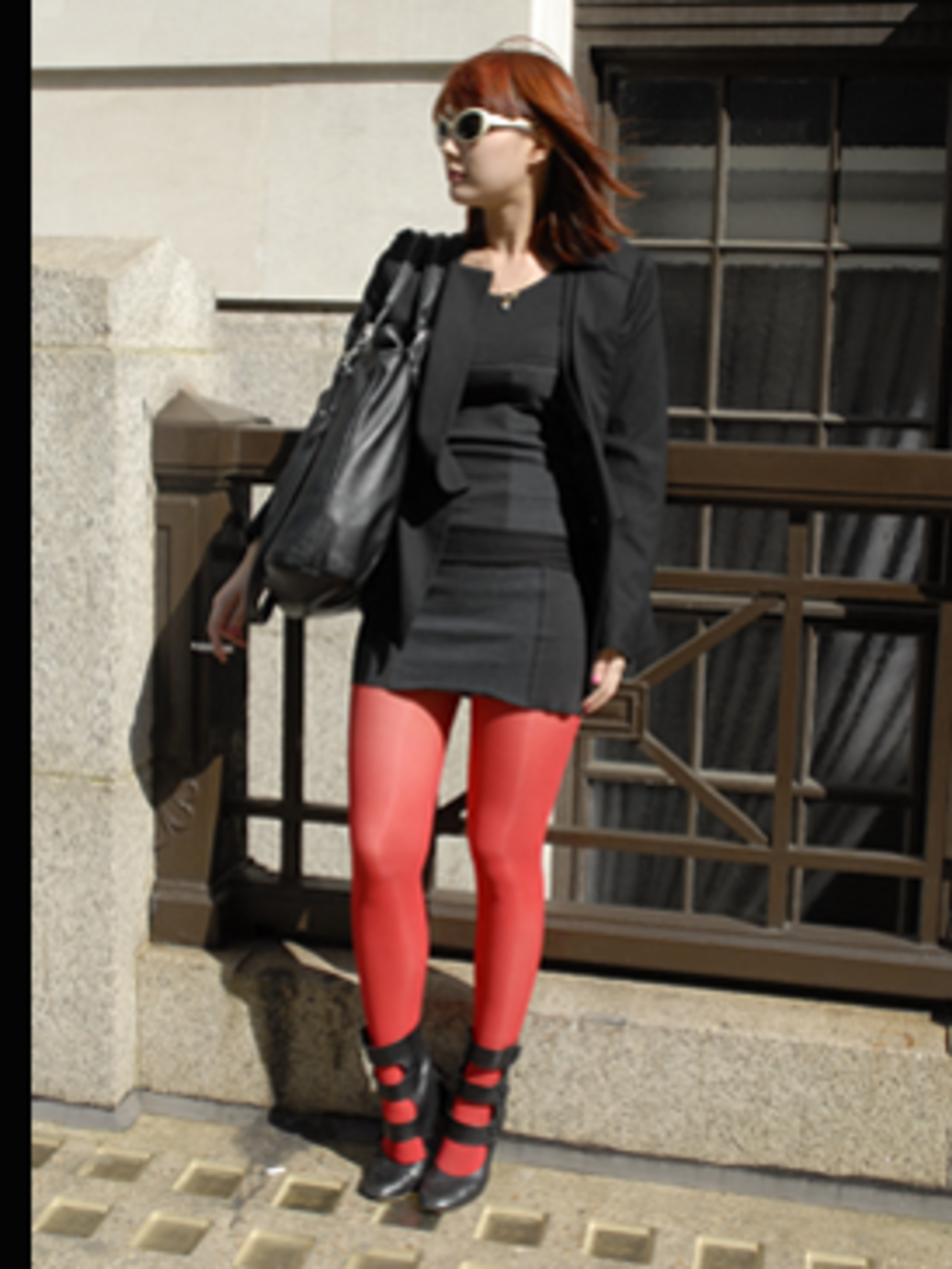 <p>A chic black outfit is given a kooky edge with bright red tights and matching hair. The Eley Kishimoto fetish-esque shoes add sex appeal.</p>