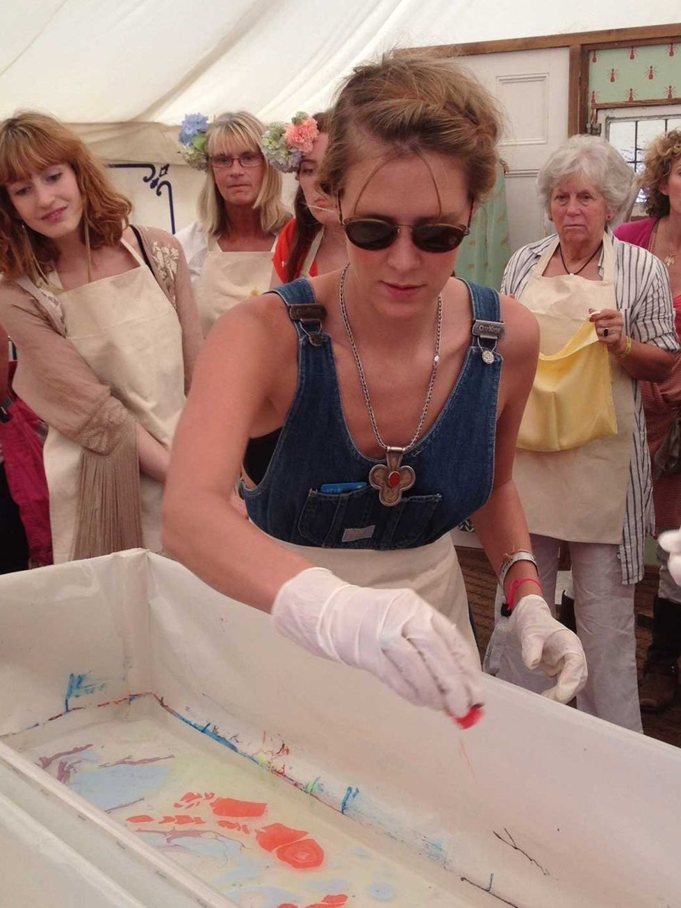 <p>Taylor began her marble-printing demonstration by dropping ink into a water trough before using a fork to swirl the colours together</p>