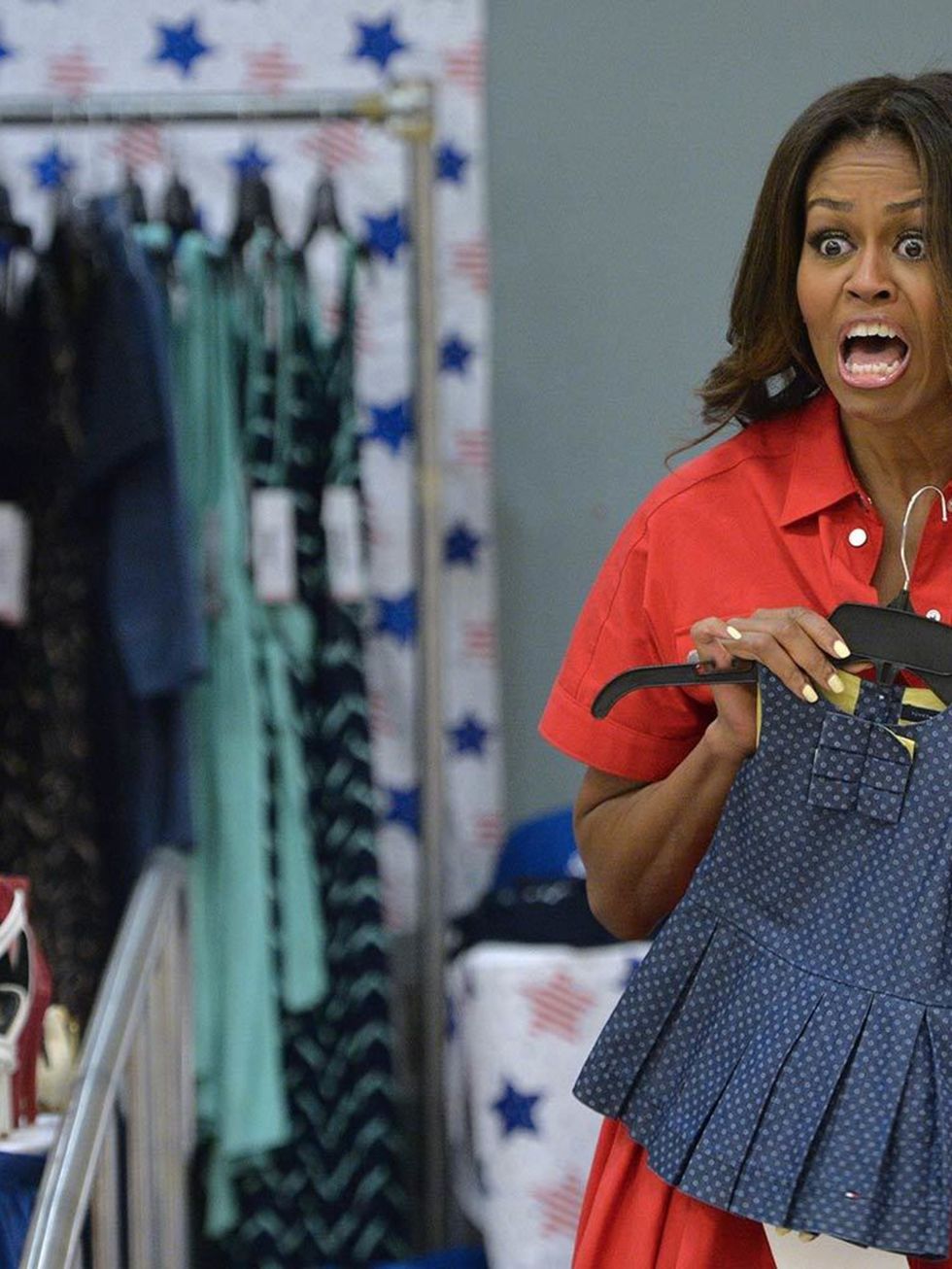Michelle Obama holds children's clothing as she meets with women expecting babies at the United States and Nato military base in Aviano, Italy, June 2015.