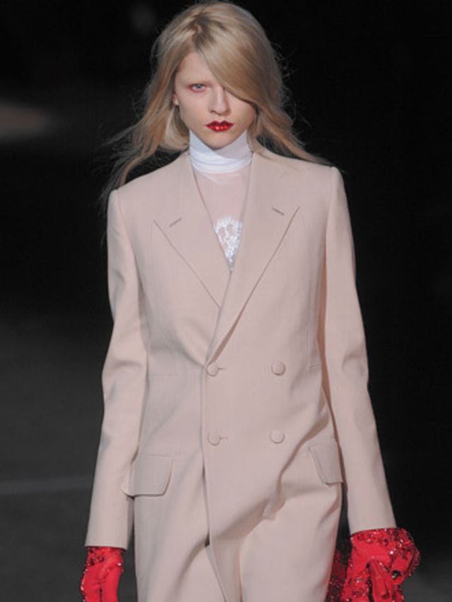 <p>Givenchy whispers rather than shouts and its stripped-down blazers, ankle-length cigarette pants and sheer neoprene roll-necks lends a 1990s air. Fine cream lace tops had red lace elbow patches and black lace bibs. True red long-line blazers were stron