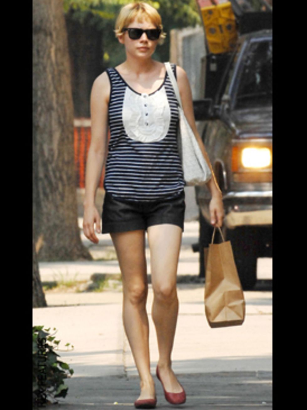 <p>Michelle teams her nautical striped McQ vest with simple navy shorts and punchy red pumps</p>