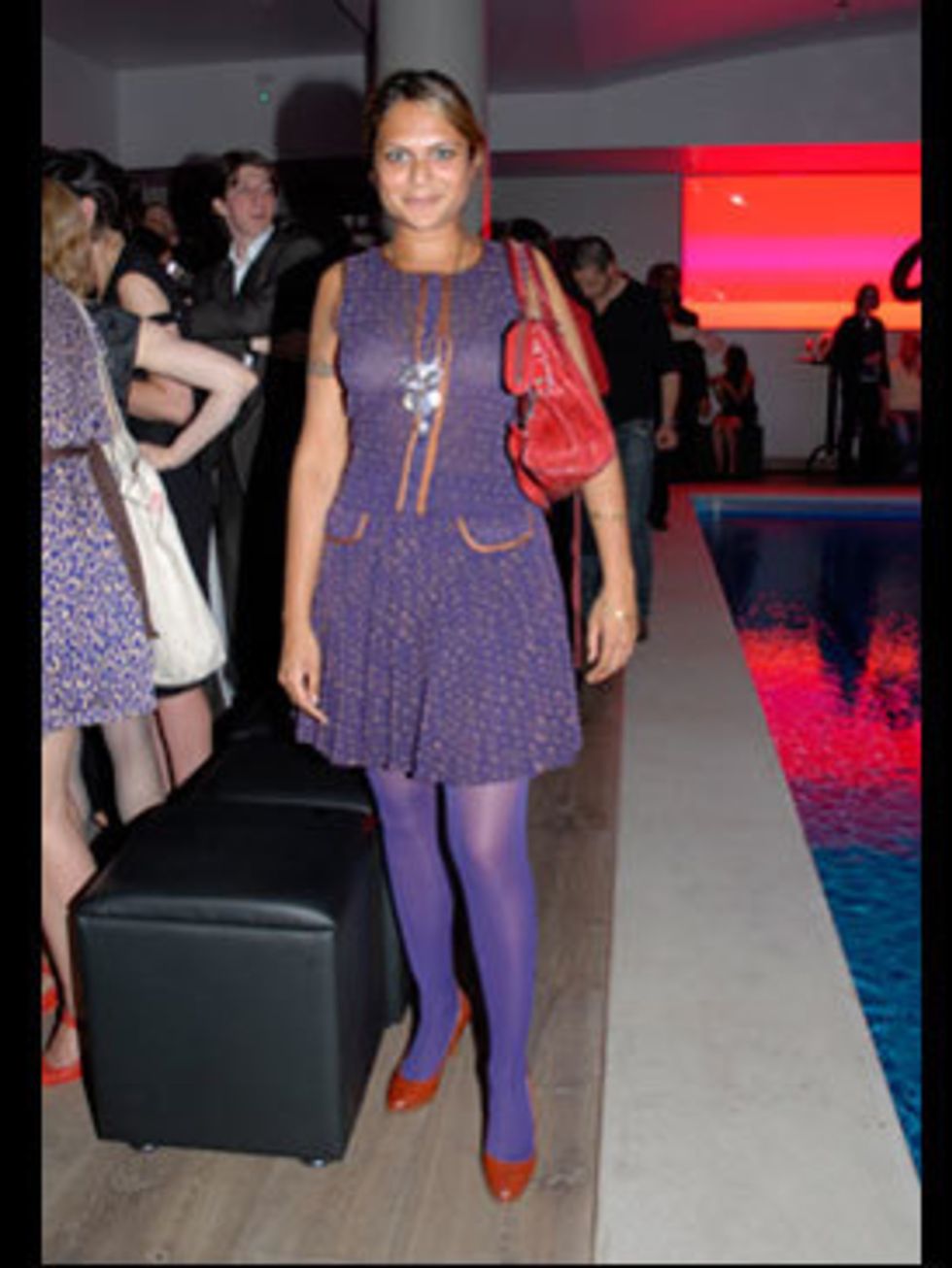 <p>Yet another purple dress/red shoe combo. The dress was from a little boutique in New York, while her eye-catching bag is by Balenciaga. The purple tights and red bag make this a daring combination.</p>