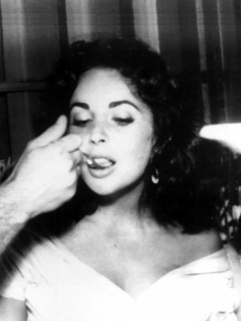 <p><a href="http://www.elleuk.com/starstyle/special-features/%28section%29/elizabeth-taylor-a-retrospective">Elizabeth Taylor</a> is fed wedding cake by her new husband Mike Todd after their wedding in Mexico, 1957</p>