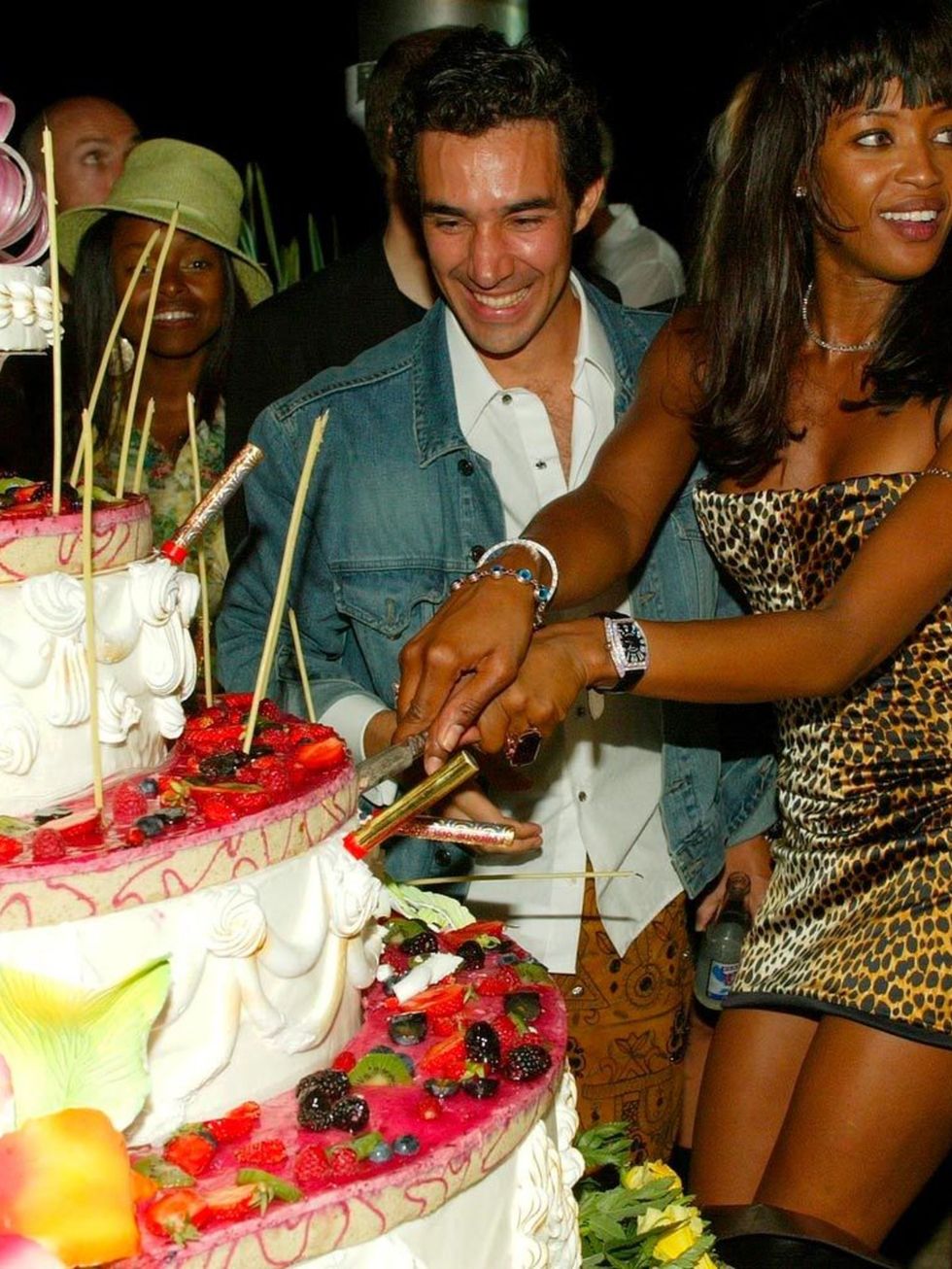 <p>Naomi Campbell cuts her cake.</p>