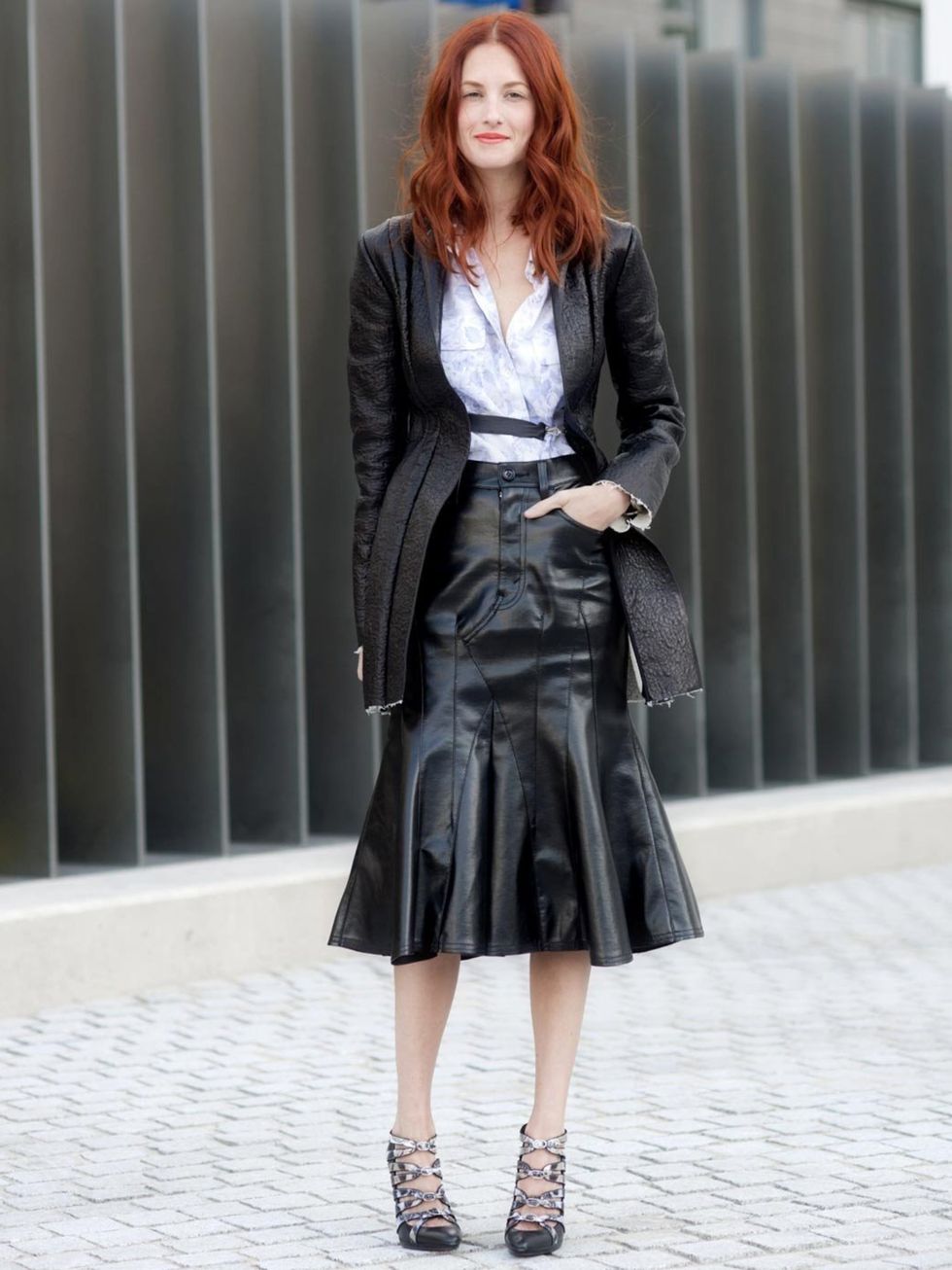 <p>Taylor Tomasi Hill teams her leather peplum skirt with asymmetrical skirt and lace up sandals during Milan fashion Week.</p>
