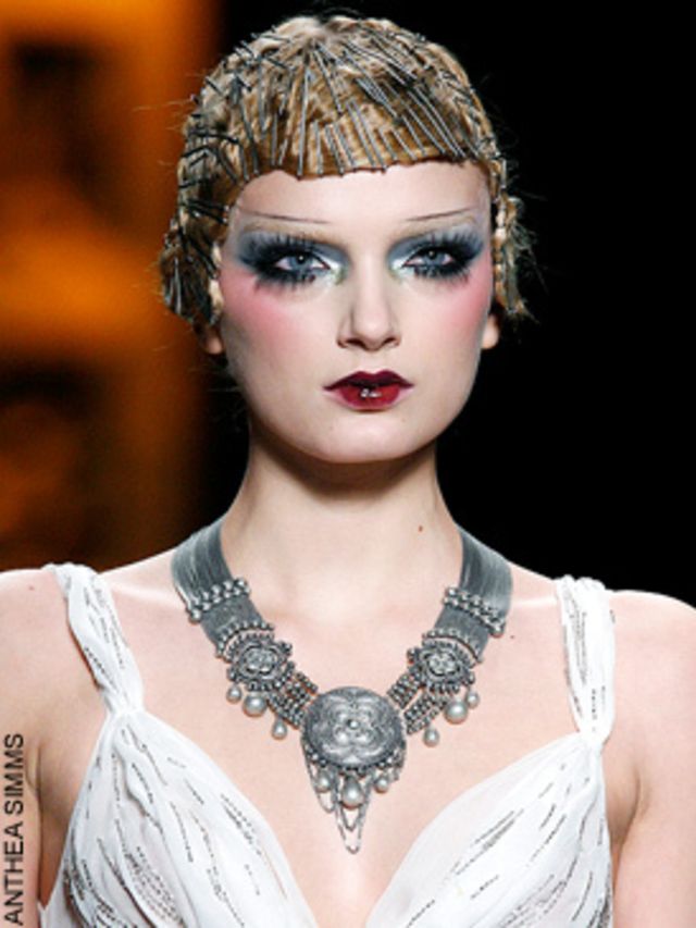 <p>Models with requisite pencilled eyebrows, dark, dramatic lips and hair sculpted with bobby pins into glittering helmets, shimmied down the catwalk in a series of drop waisted skirt suits, fur trimmed coats and jewelled dresses all in a longer elegant m