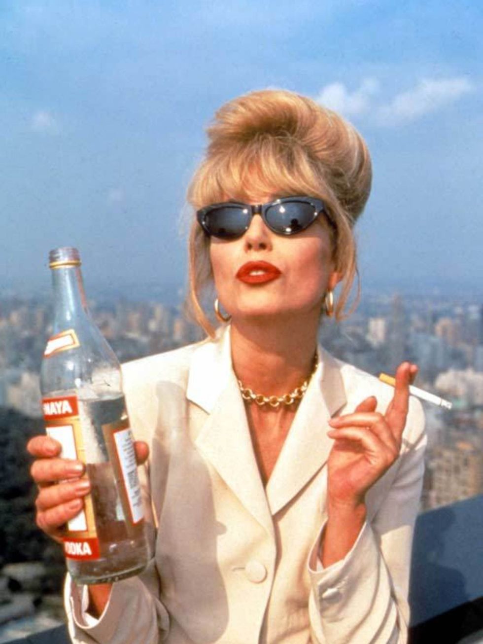 <p>Patsy poses in a cream suit and cats eye sunglasses with her tipple of choice in 'Ab Fab'</p>
