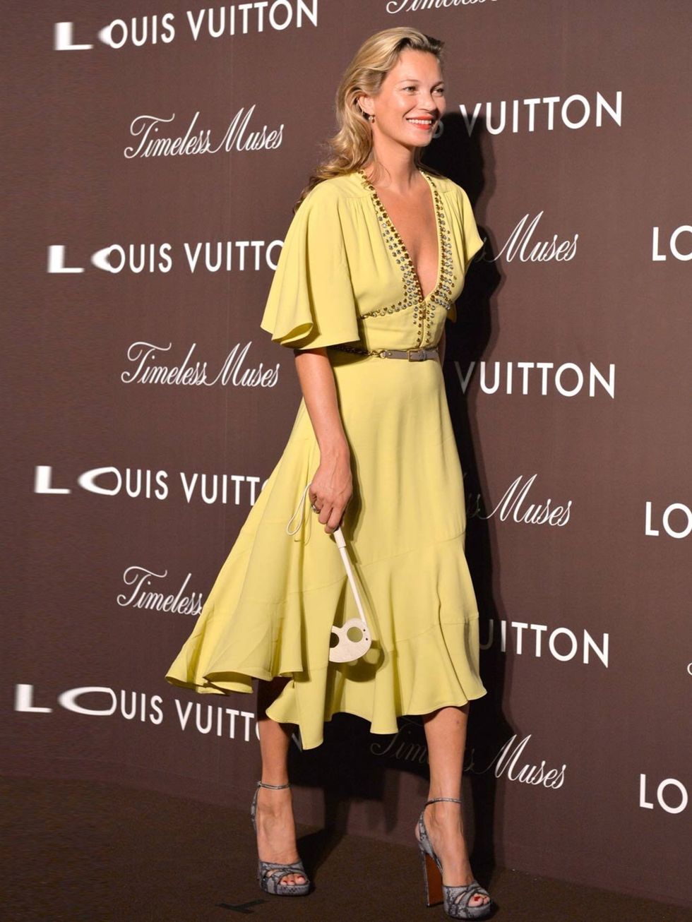 <p>Kate Moss wearing a soft-yellow Louis Vuitton Resort 2014 dress styled with Louis Vuitton pouch and grey Louis Vuitton heels from the Autumn 2013 collection, attends the Louis Vuitton 'Timeless Muses' exhibition at the Tokyo Station Hotel on August 29,