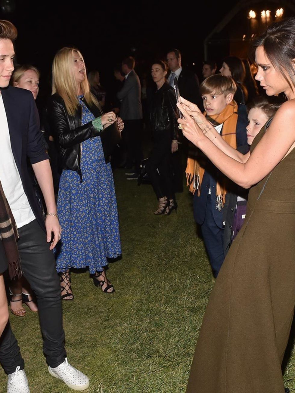 <p>Victoria takes of snap of Brooklyn and Cara Delevingne for Brooklyn's instagram during Burberry's 'London in Los Angeles' event, April 2015</p>