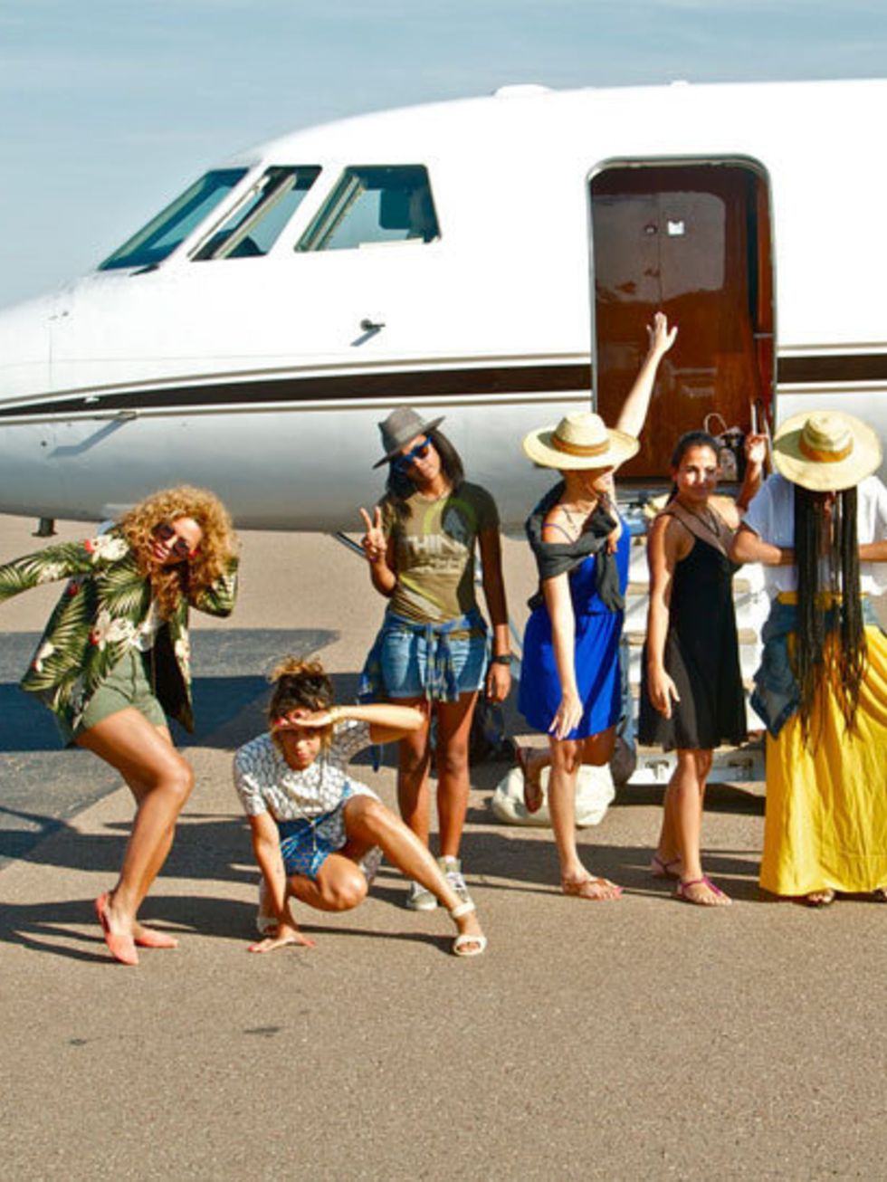 <p>Beyonce and her friends posing in front of a private jet</p>