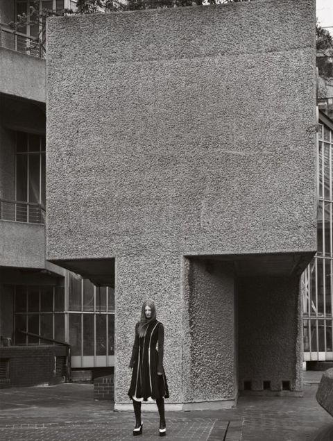 Standing, Wall, Street fashion, Monochrome, Overcoat, Monochrome photography, Black-and-white, Frock coat, 