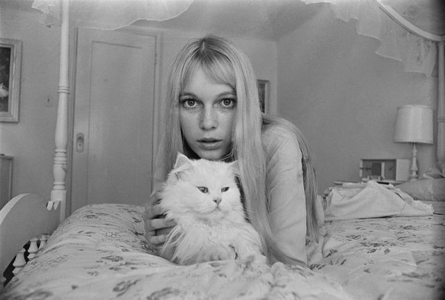 Mia Farrow on bed with a cat
