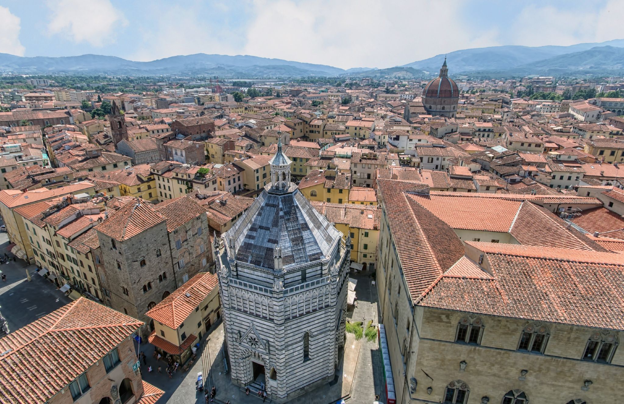 The octagonal 14th-century Baptistery amid the red pan-tiled roofs of Pistoia, Italy 

