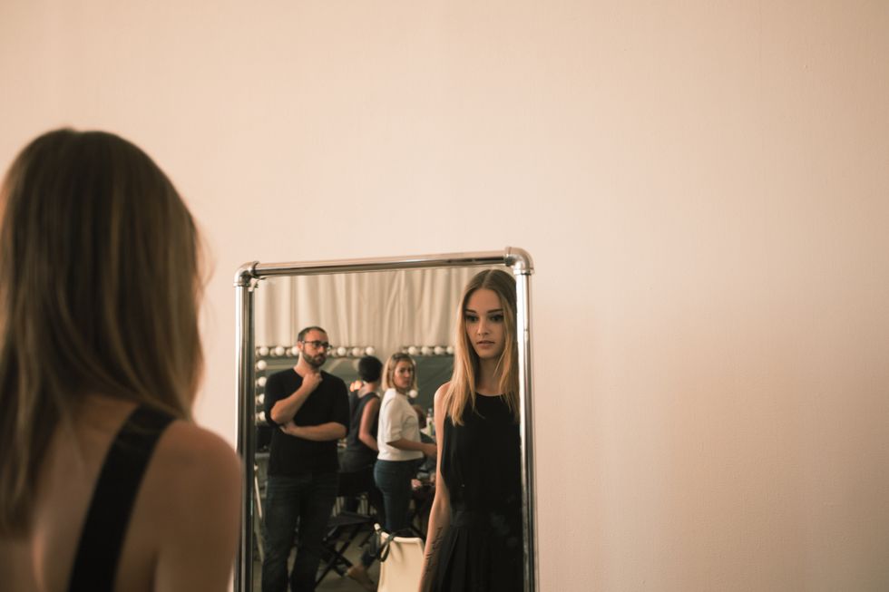 Woman looking at herself in the mirror - woman looking at her reflection