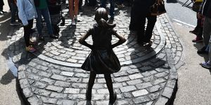 Fearless girl statue surrounded by a crowd