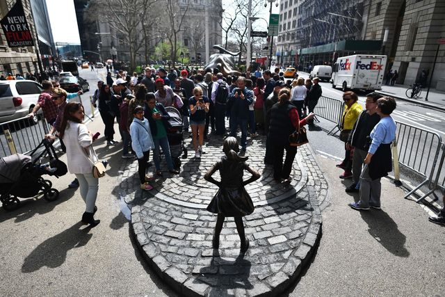 Fearless girl statue surrounded by a crowd