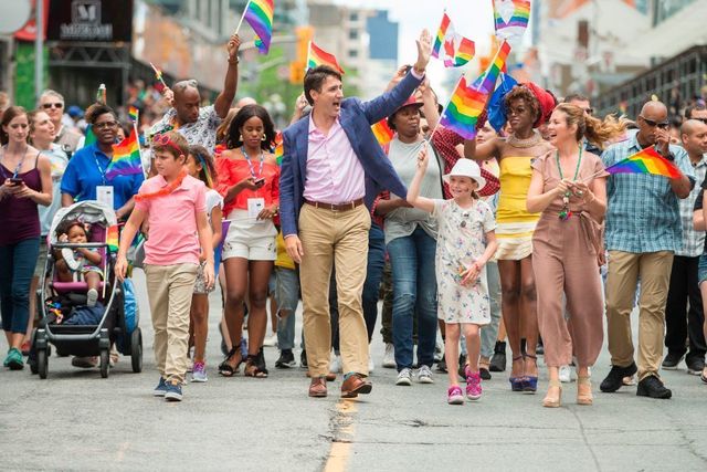 Prime Minister Justin Trudeau waves to the crowd as he, his wife Sophie Gregoire Trudeau and their children Xavier and Ella-Grace march in the Pride Parade in Toronto | ELLE UK